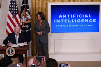 caption: Vice President Harris watches as President Biden signs an executive order on artificial intelligence on Oct. 30. On Thursday, the Biden administration issued new rules on how government agencies can implement AI.