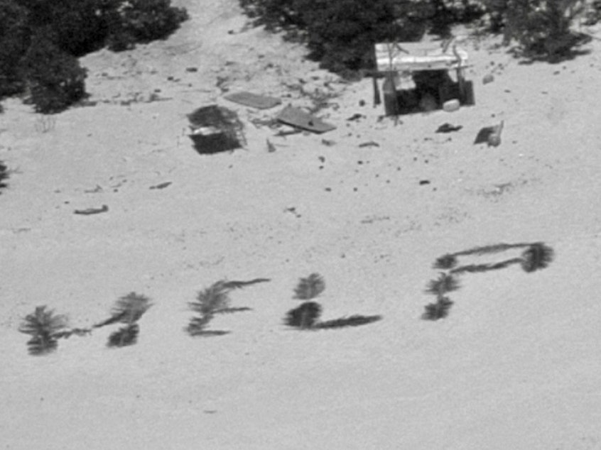 caption: The 'HELP' sign made from palm fronds is shown on the Pikelot atoll.