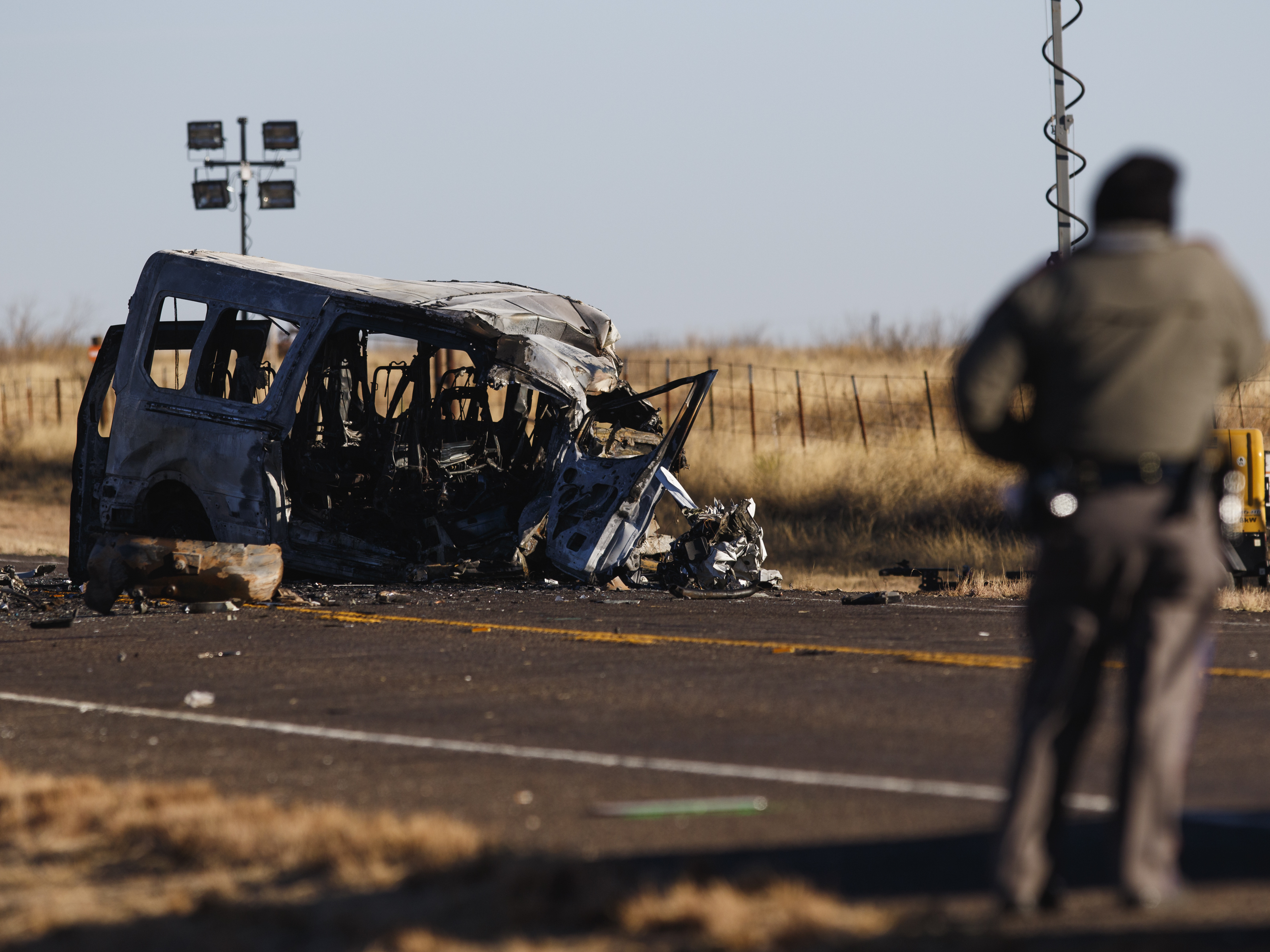 caption: Texas Department of Public Safety Troopers look over the scene of a fatal collision in March in Andrews County, Texas. A pickup truck crossed the center line of a two-lane road and crashed into a van carrying members of the University of the Southwest men's and women's golf teams.