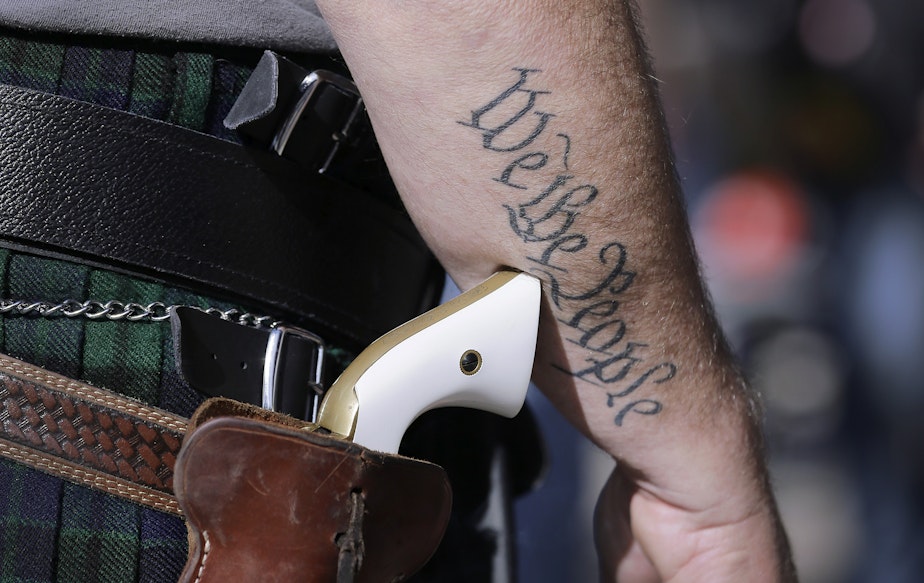caption: In this Jan. 26, 2015, file photo, Scott Smith, a supporter of open carry gun laws, wears a pistol as he prepares for a rally in support of open carry gun laws at the Capitol, in Austin, Texas.