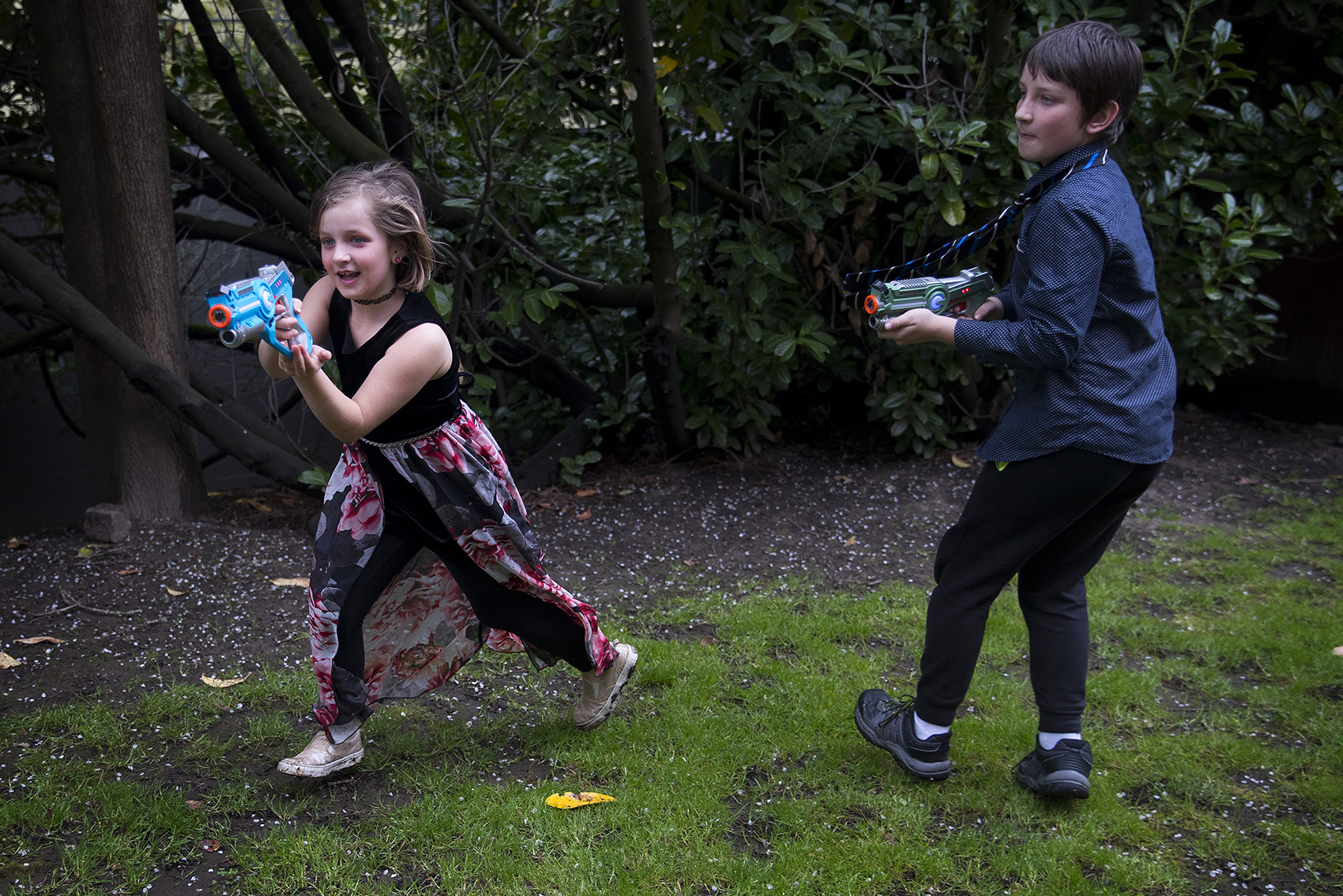 caption: Amaleia McCarty, 8, left, and Xaven McCarty, 11, play laser tag during Xaven's birthday party on Sunday, April 7, 2019, at their home in Seattle. 