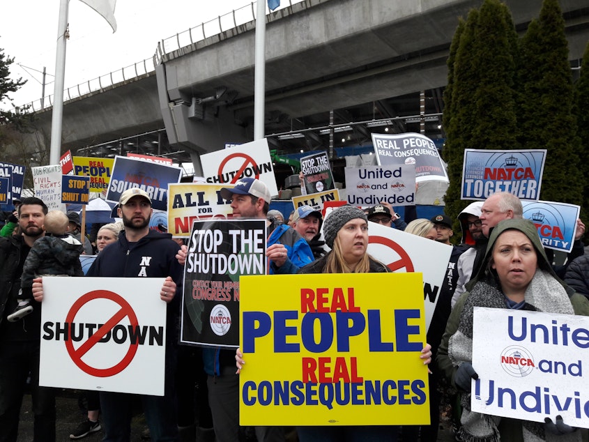 caption: TSA screeners and air traffic controllers called for an end to the partial government shutdown during a rally outside Seattle-Tacoma International Airport on Tuesday.