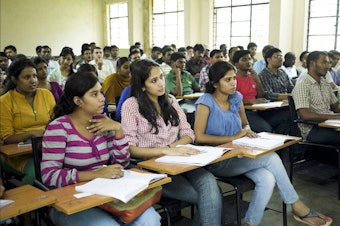 caption: Students sit in a computer science class taught by professor Chakravarthy Bhagavati at the University of Hyderabad.