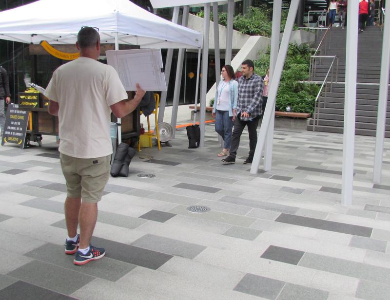 caption: "No Tax on Jobs" volunteer Mike Hamstra seeks signatures near Amazon banana station. Amazon opposed the employee head tax.
