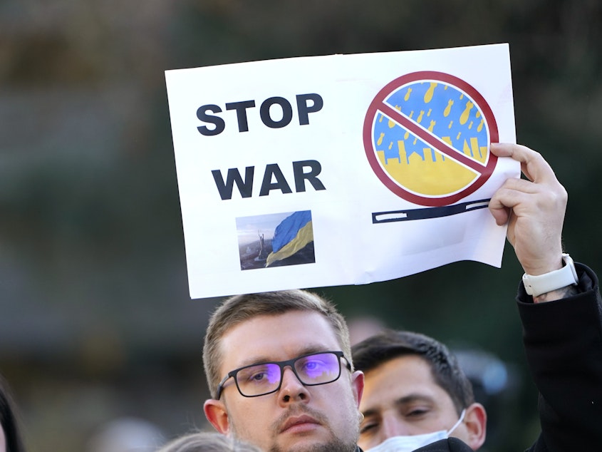 caption: Demonstrators show support for Ukraine in response to Russia's invasion of the country on Thursday in Seattle.