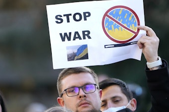 caption: Demonstrators show support for Ukraine in response to Russia's invasion of the country on Thursday in Seattle.