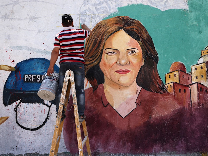 caption: Palestinian artists paint a mural in honor of slain veteran Al Jazeera journalist Shireen Abu Akleh in Gaza City, after she was killed on May 11. A new U.N. report says Israeli forces fired the shots that killed Abu Akleh and injured a colleague.