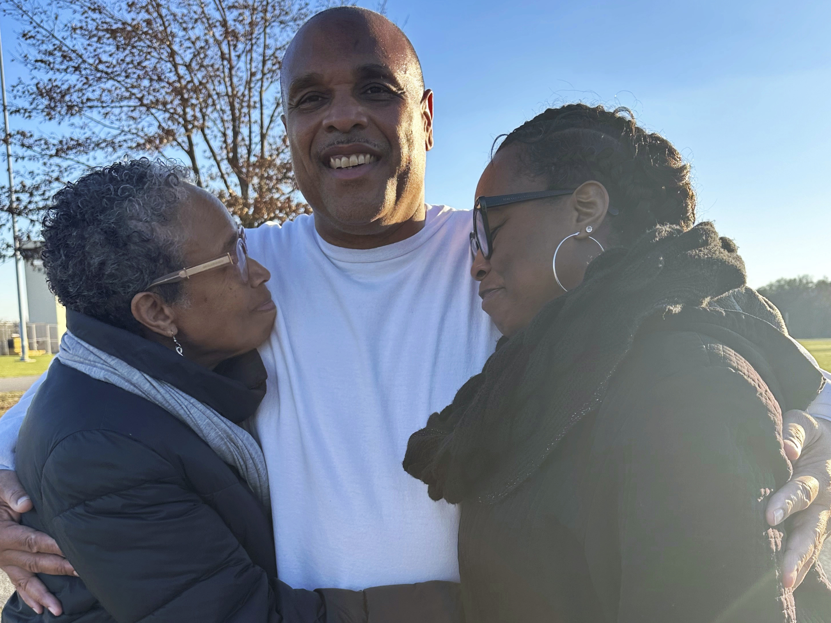 caption: In this photo provided by Laura Nirider, Brian Beals, center, who was exonerated on a murder charge and released from a downstate prison after 35 years behind bars, hugs his sister Pattilyn Beals, left, and niece Tamiko Beals outside Robinson Correctional Institution, in Robinson, Ill., on Tuesday, Dec. 12, 2023.