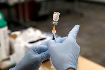 caption: A nurse practitioner fills a syringe with the Pfizer COVID-19 vaccine at the Beaumont Health offices in Southfield, Mich., on Nov. 5.