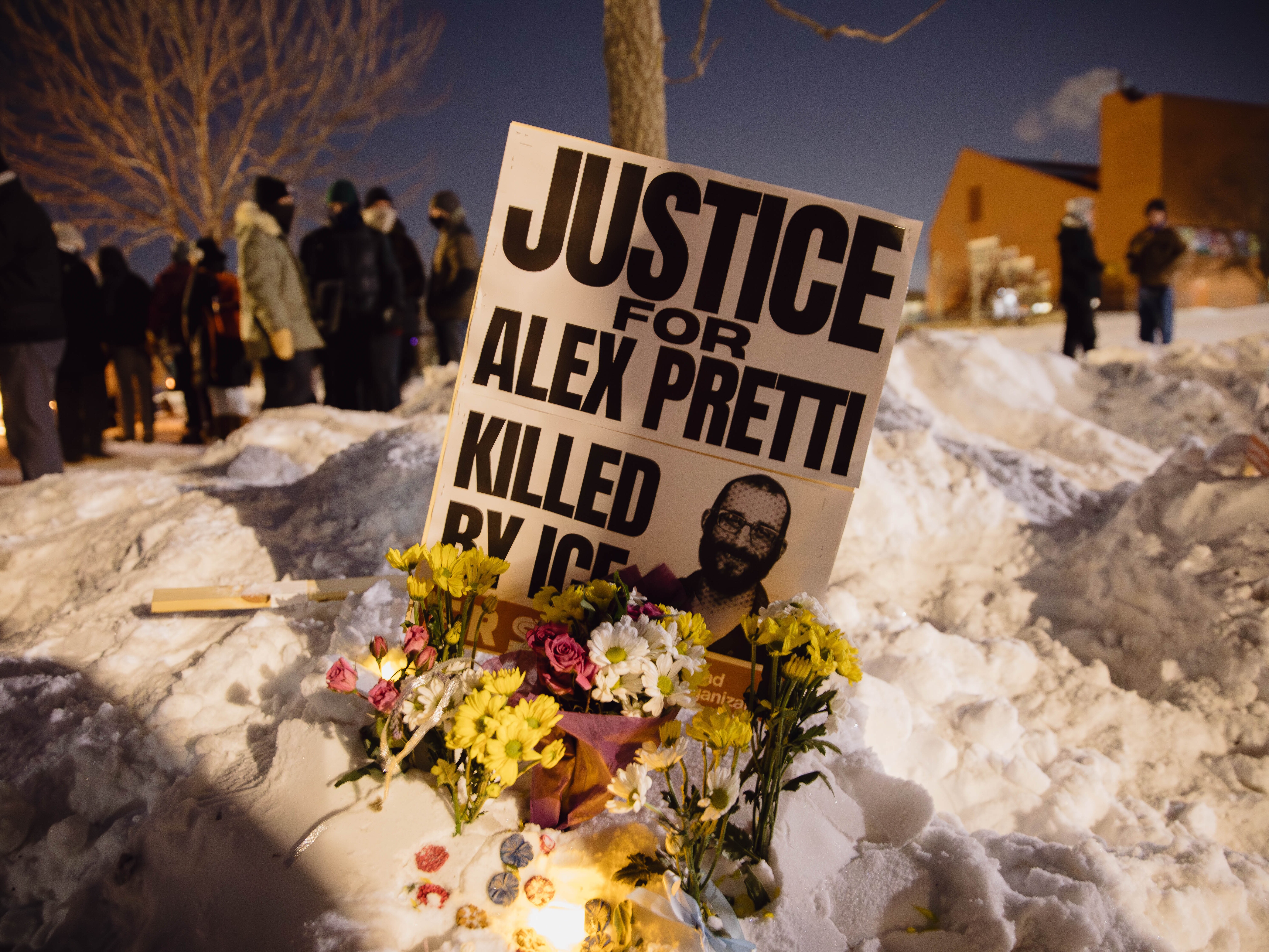 caption: A sign for Alex Pretti, who was killed earlier in the day by a U.S. Border Patrol officer, is displayed during a vigil Saturday in Minneapolis.
