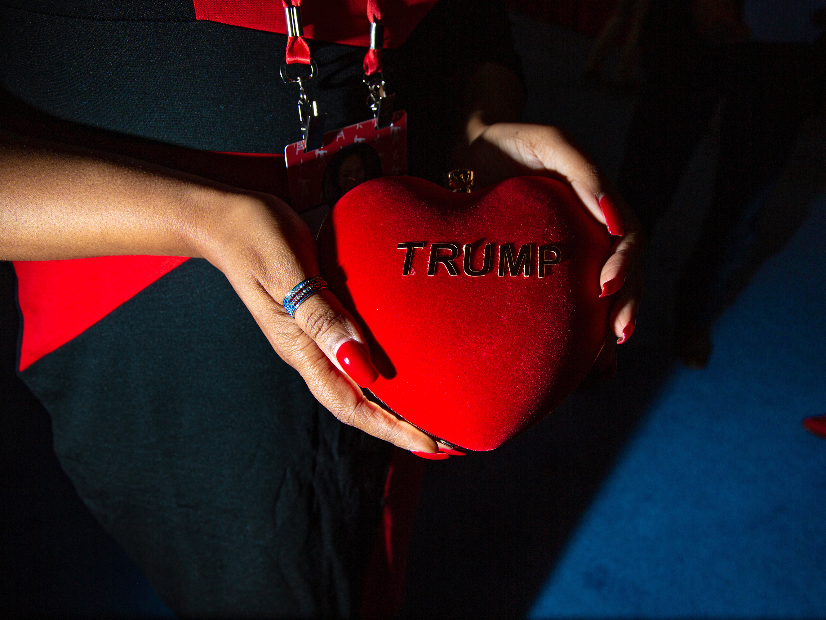 caption: A CPAC attendee holds a heart shaped purse reading "Trump."