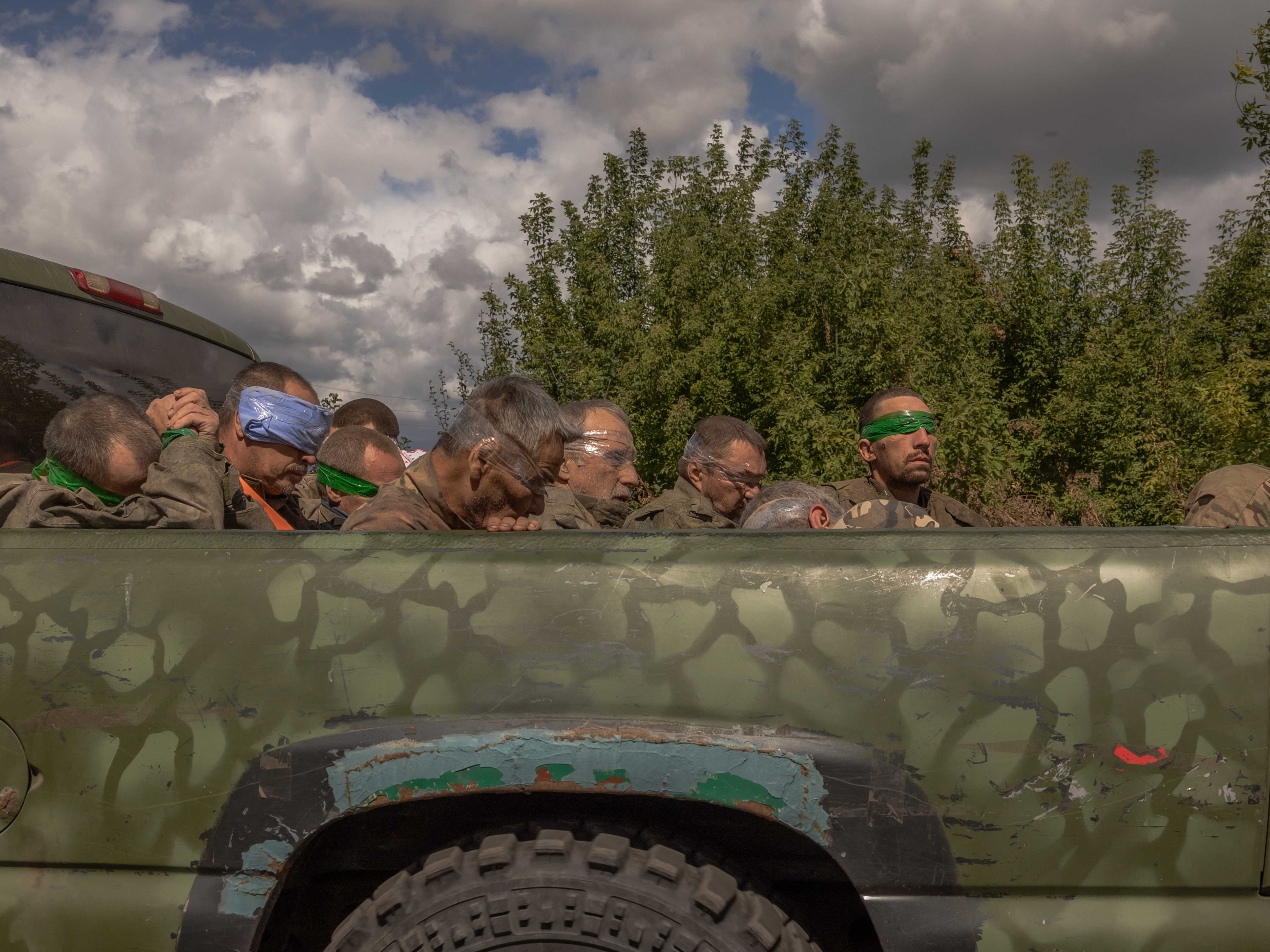 caption: A Ukrainian military vehicle filled with captured Russian troops travels on the Ukrainian side of the border with Russia on Tuesday. Ukraine's President Volodymyr Zelenskyy says Ukraine has captured hundreds of Russian fighters since it launched its invasion into the Kursk region of western Russia on Aug. 6.