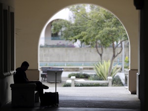 caption: A man studies on the San Diego State University campus on March 12. San Diego State is a part of the California State University system and will be subject to the new general education requirement.