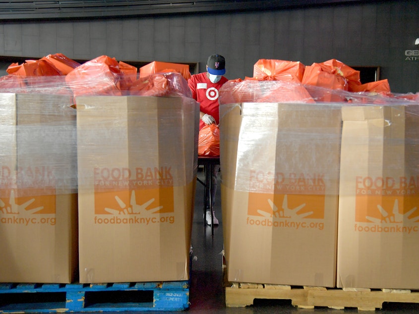 caption: New Yorkers in need receive free produce, dry goods and meat at a Food Bank For New York City distribution event on July 30, 2020.