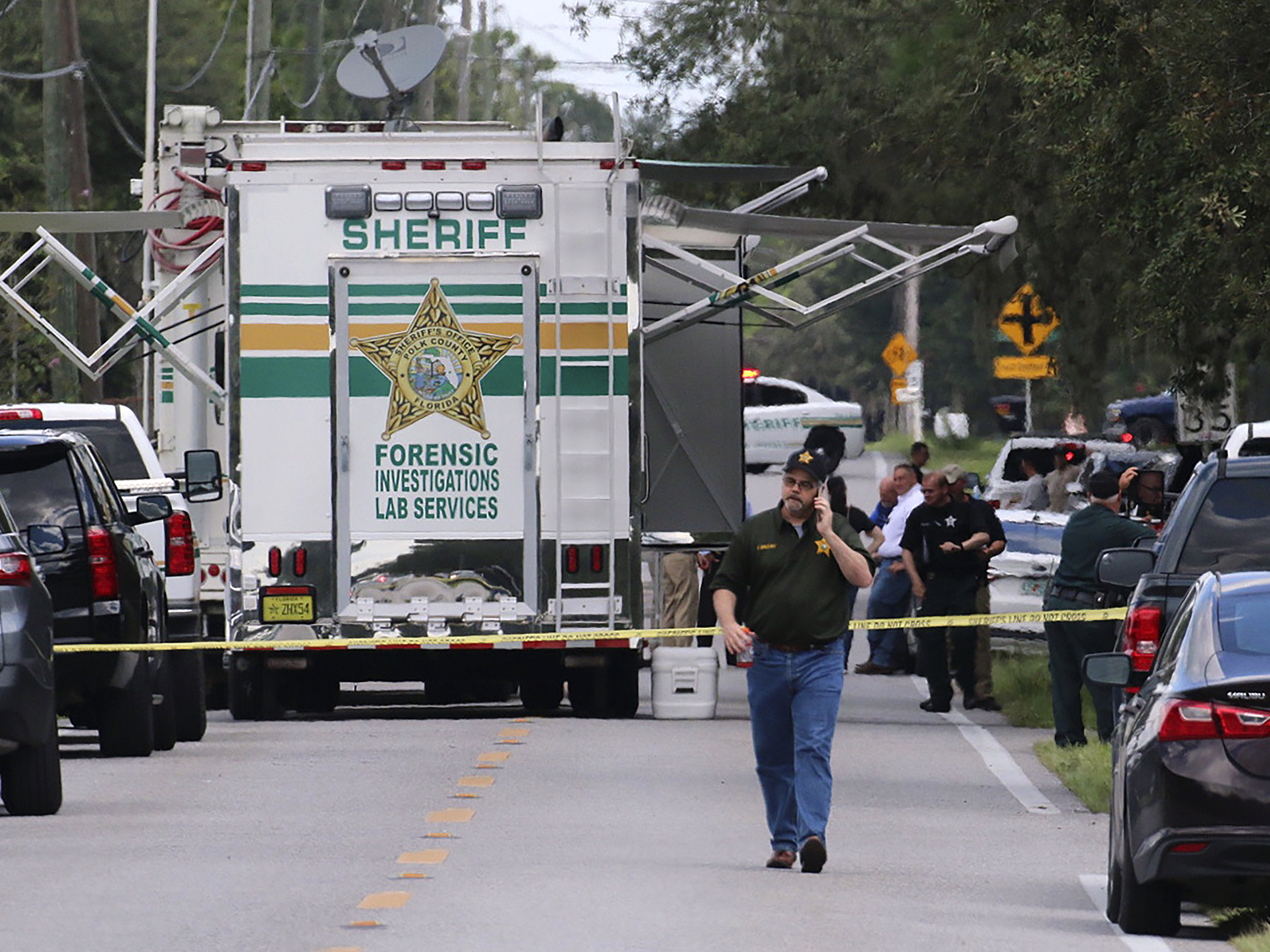caption: Polk County, Fla., Sheriff's officials work the scene of a multiple fatality shooting Sunday, in Lakeland, Fla.