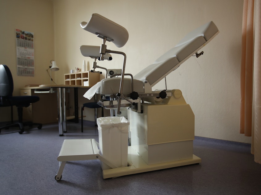 caption: A gynecology chair sits in a doctor's office.