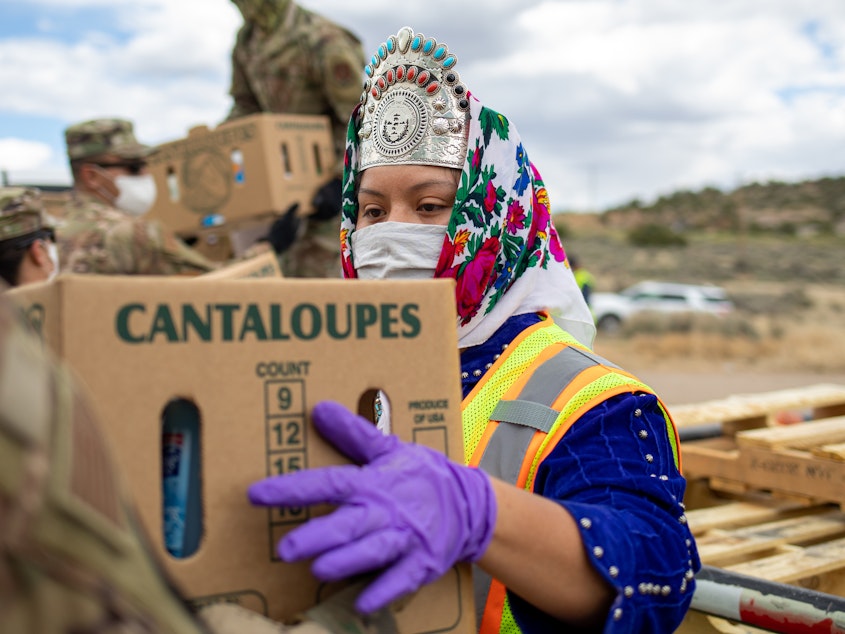 caption: Shaandiin Parrish, who was then Miss Navajo Nation, grabs a box filled with food and other supplies to distribute to Navajo families on May 27, 2020, in Counselor on the Navajo Nation Reservation, New Mexico.