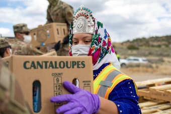 caption: Shaandiin Parrish, who was then Miss Navajo Nation, grabs a box filled with food and other supplies to distribute to Navajo families on May 27, 2020, in Counselor on the Navajo Nation Reservation, New Mexico.