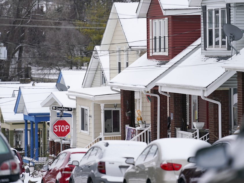 caption: Snow blankets a row of homes after a snowstorm in Bellevue, Ky., on Friday.