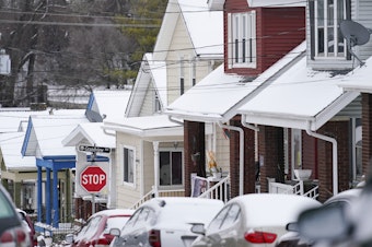 caption: Snow blankets a row of homes after a snowstorm in Bellevue, Ky., on Friday.