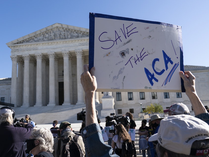 caption: A demonstrator holds a sign in support of the Affordable Care Act in front of the U.S. Supreme Court last November. On Thursday, the justices did just that.