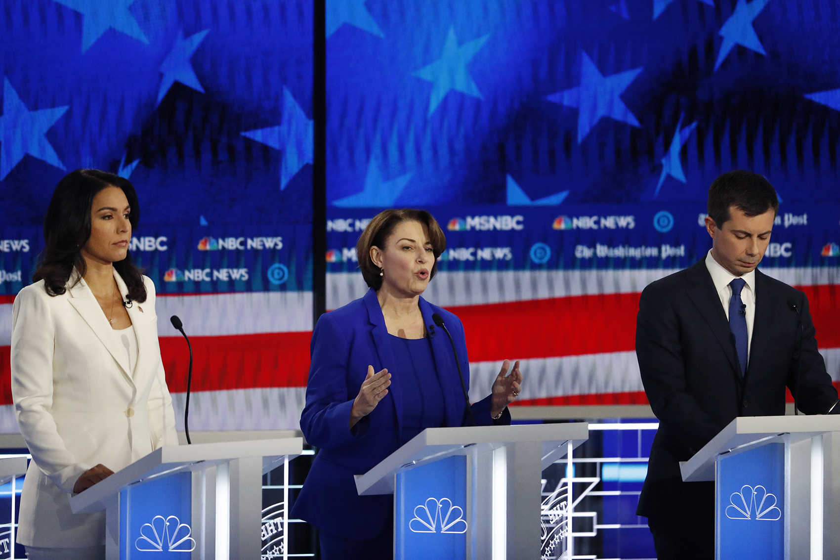 caption: Democratic presidential candidate Sen. Amy Klobuchar, D-Minn., center, speaks as South Bend, Ind., Mayor Pete Buttigieg and Rep. Tulsi Gabbard, D-Hawaii, listen during a Democratic presidential primary debate, Wednesday, Nov. 20, 2019, in Atlanta. (John Bazemore/AP)