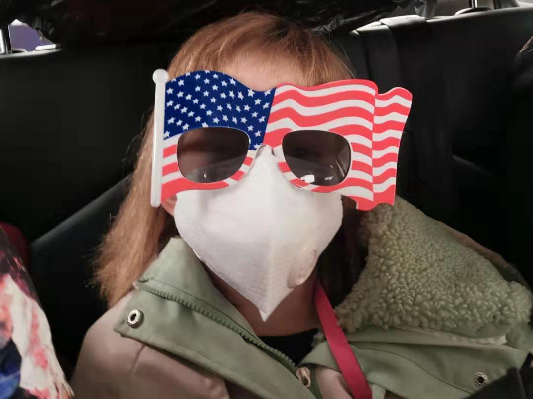 caption: Hermione Dickey, 8, and her mother, Priscilla, are among the passengers on a U.S. evacuation flight out of Wuhan, China. She's seen here during the car ride to Wuhan Tianhe International Airport.