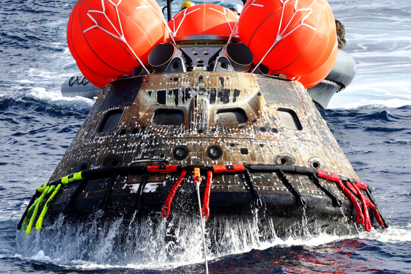 caption: NASA's Orion capsule is drawn to the well deck of the USS Portland after it splashed down following a successful uncrewed Artemis I moon mission, Sunday, Dec. 11, 2022, in the Pacific Ocean off the coast of Baja California, Mexico. 