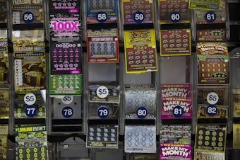 caption: The lottery ticket display behind the counter at College Convenience on Huntington Avenue. (Jesse Costa/WBUR)