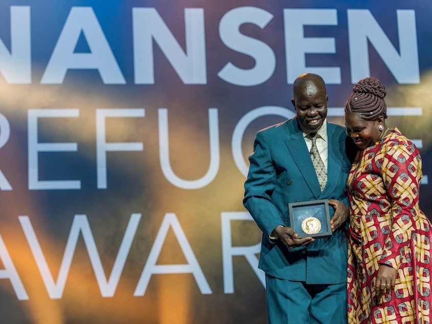 caption: Evan Atar Adaha, surgeon and medical director at a hospital in South Sudan, accepts the U.N.'s Nansen Refugee Award in Geneva, on October 1. His wife, Angela Atar, is at right.