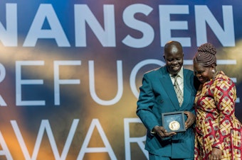 caption: Evan Atar Adaha, surgeon and medical director at a hospital in South Sudan, accepts the U.N.'s Nansen Refugee Award in Geneva, on October 1. His wife, Angela Atar, is at right.