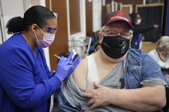 caption: Shana Alesi administers a COVID-19 booster vaccine to Marine Corps veteran Bill Fatz at the Edward Hines Jr. VA Hospital in Hines, Ill., in 2021. A new round of boosters could become available for some people this spring.