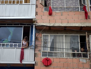 caption: Residents of the Colombian capital Bogotá hang red rags from their windows and balconies to signal their need for help with food during the coronavirus pandemic.
