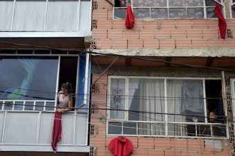 caption: Residents of the Colombian capital Bogotá hang red rags from their windows and balconies to signal their need for help with food during the coronavirus pandemic.