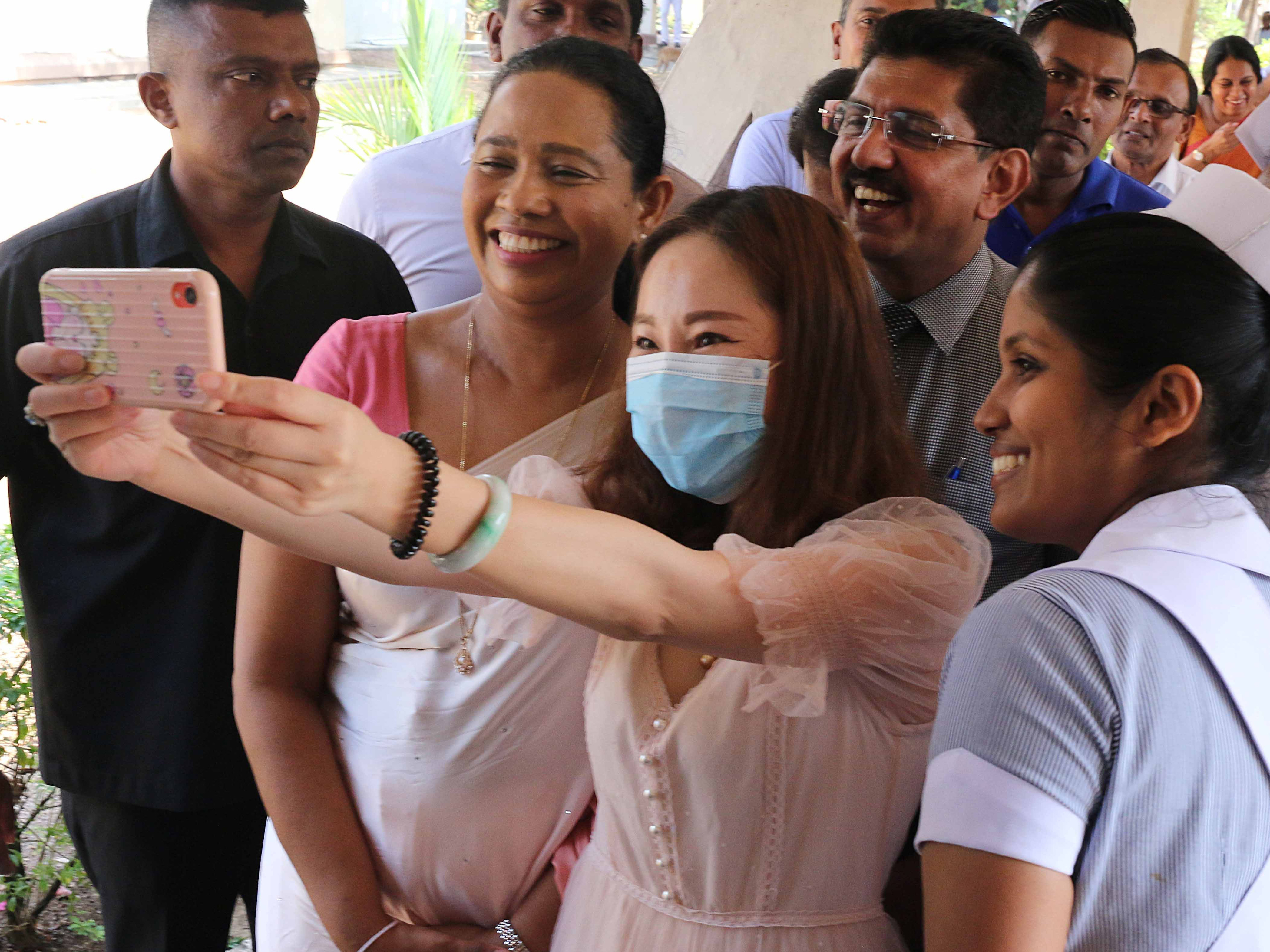caption: A recovered coronavirus patient takes a selfie before being discharged from a hospital in Sri Lanka. Researchers are trying to determine if having a case of COVID-19 will give you immunity.