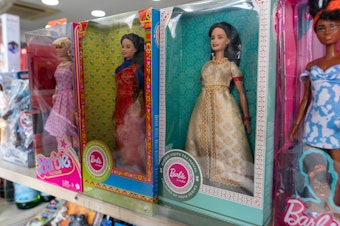 caption: The original blond Barbie sells well in India but an Indian version with dark hair and Indian-style garments did not catch on. In this store display, Indian Barbies are flanked by a fair-haired doll and an African American Barbie.