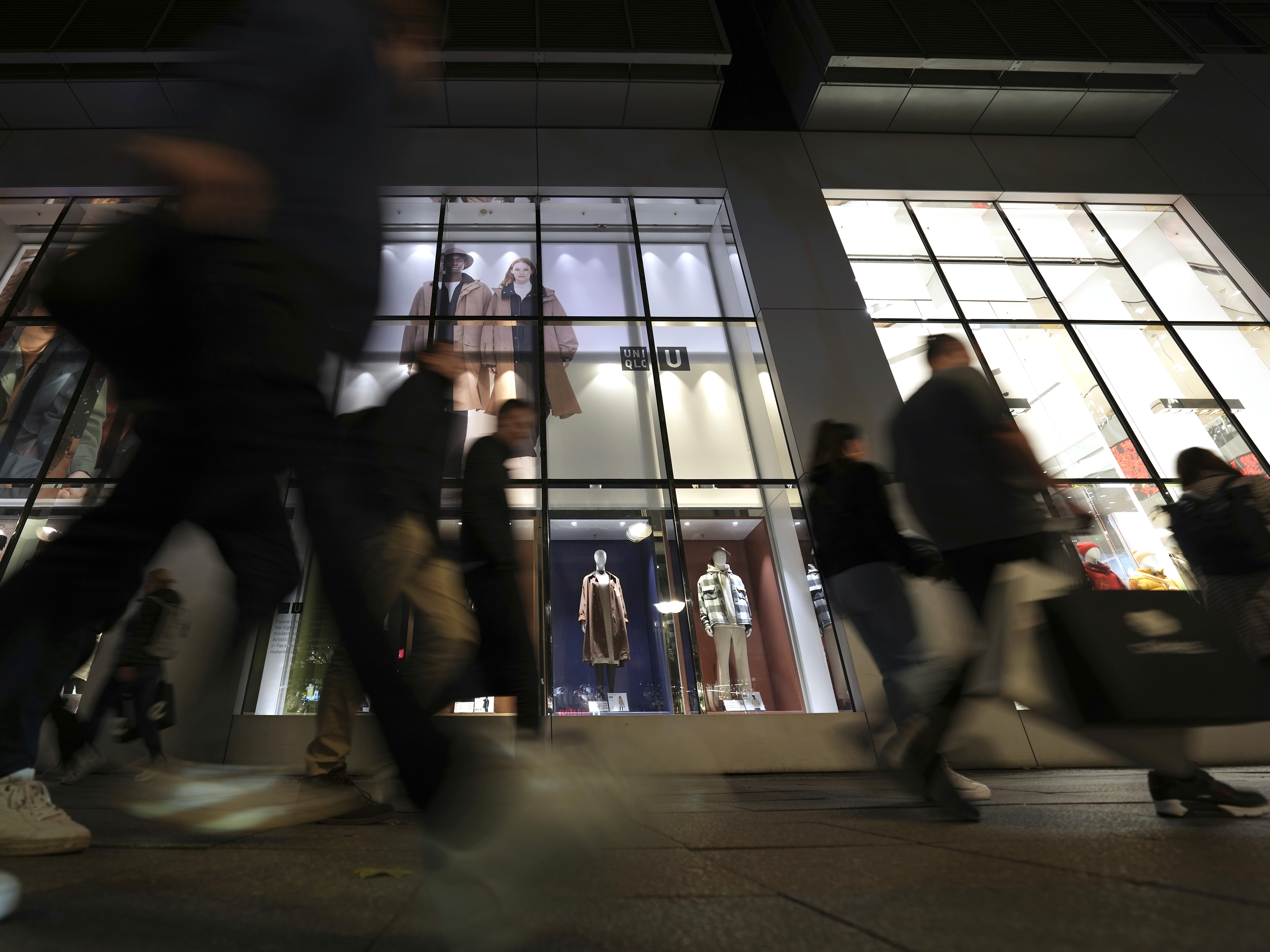 caption: People walk past a store in Berlin on Oct. 11, 2022. The German economy shrank unexpectedly in the first three months of this year.