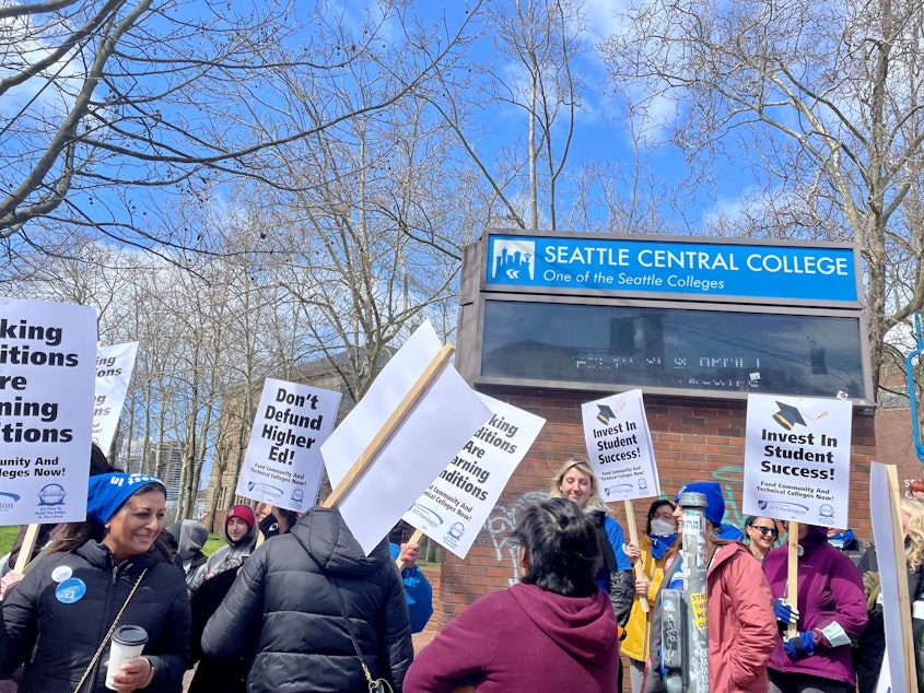 caption: After walking out of their classes on the morning of April 11, a group of Seattle Colleges faculty and staff walked to the community college district's headquarters to stage a protest demanding equitable pay raises and better working conditions.