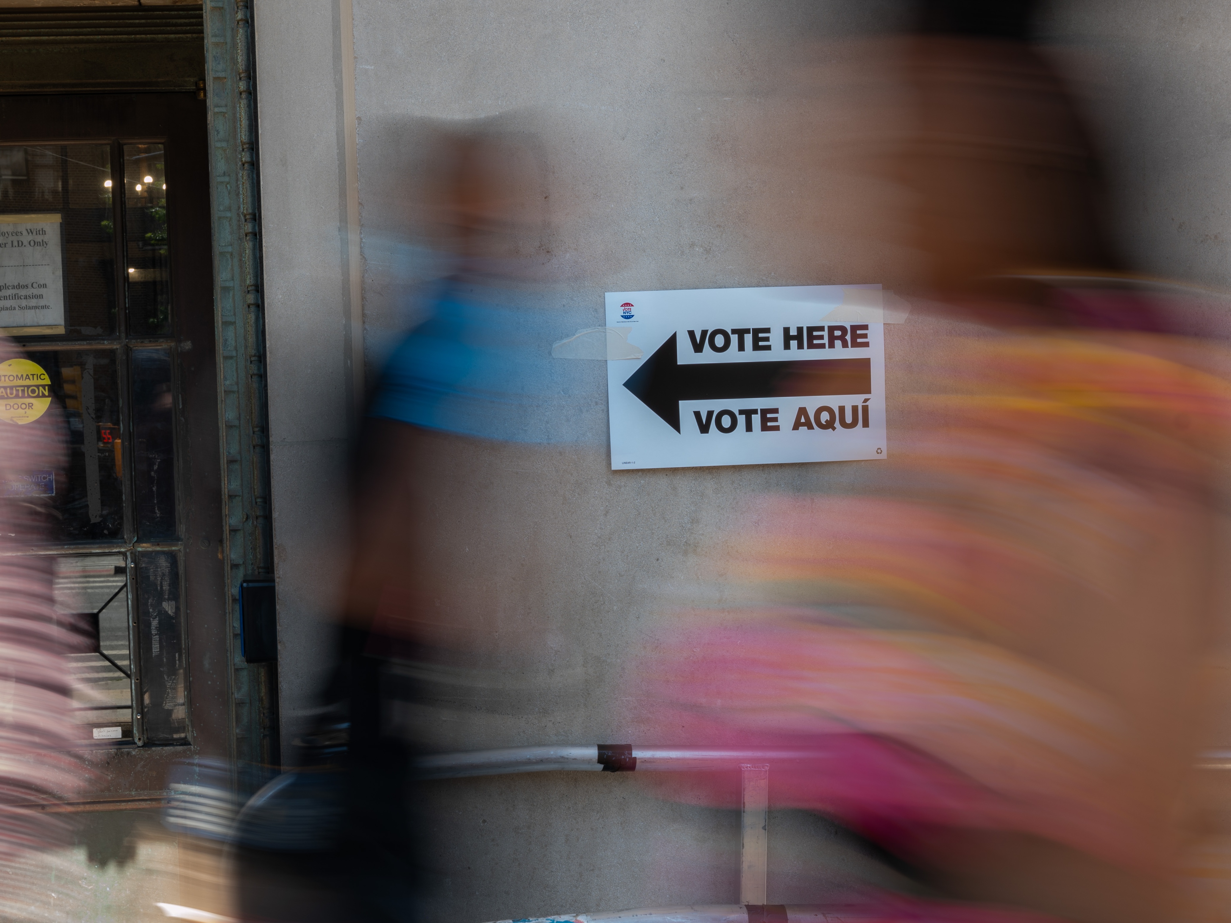 caption: In this file photo, a sign directs people to a voting site in the Bronx during the Democratic primary on June 25 in New York.