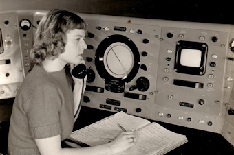 caption: Virginia Norwood sits at the Storm Detector Radar Set at the Army Signal Corps Laboratories in New Jersey in a photo displayed at the Institute for Radio Engineers Convention, Spring 1950.