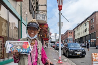 caption: Alganesh Tewelde proudly holds up a copy of International Examiner as she goes out to deliver papers to the neighborhood businesses.