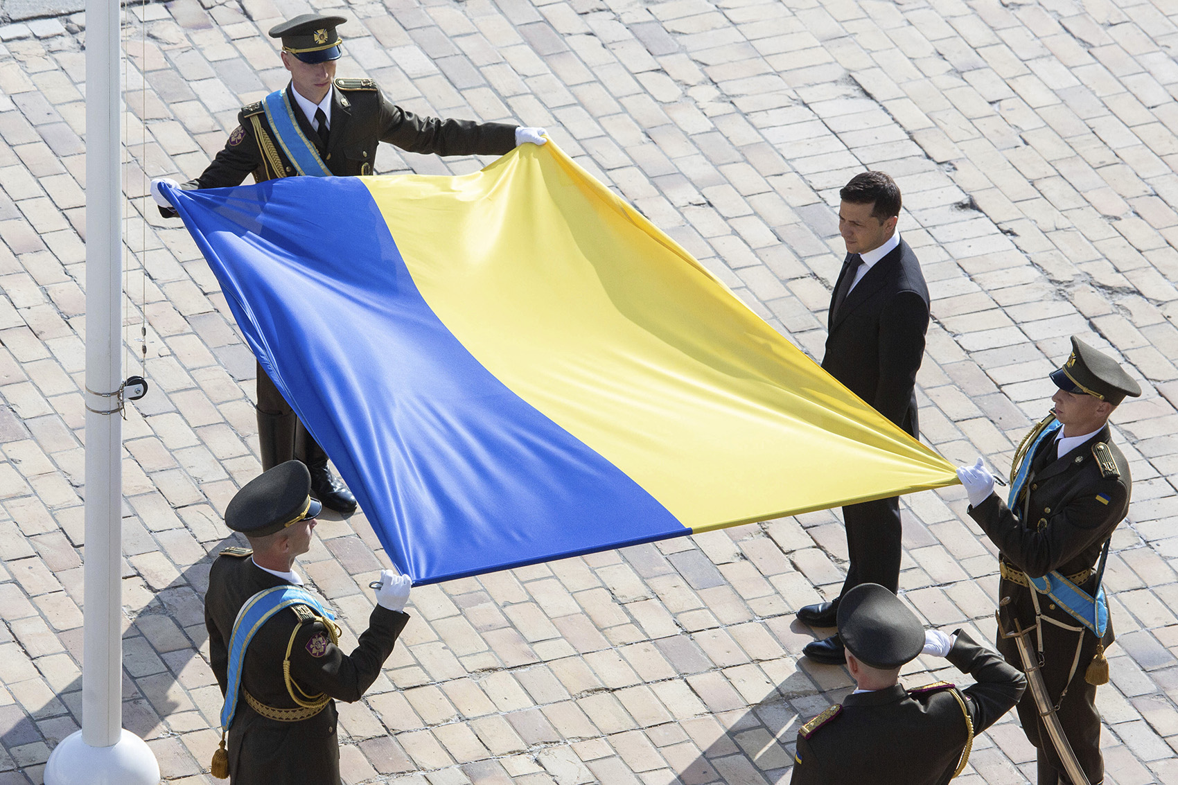 caption: Ukrainian President Volodymyr Zelenskiy, right, attends a ceremony during the National Flag Day celebration at the St. Sophia square in downtown Kyiv, Ukraine, Friday, Aug. 23, 2019. (Ukrainian Presidential Press Office via AP)