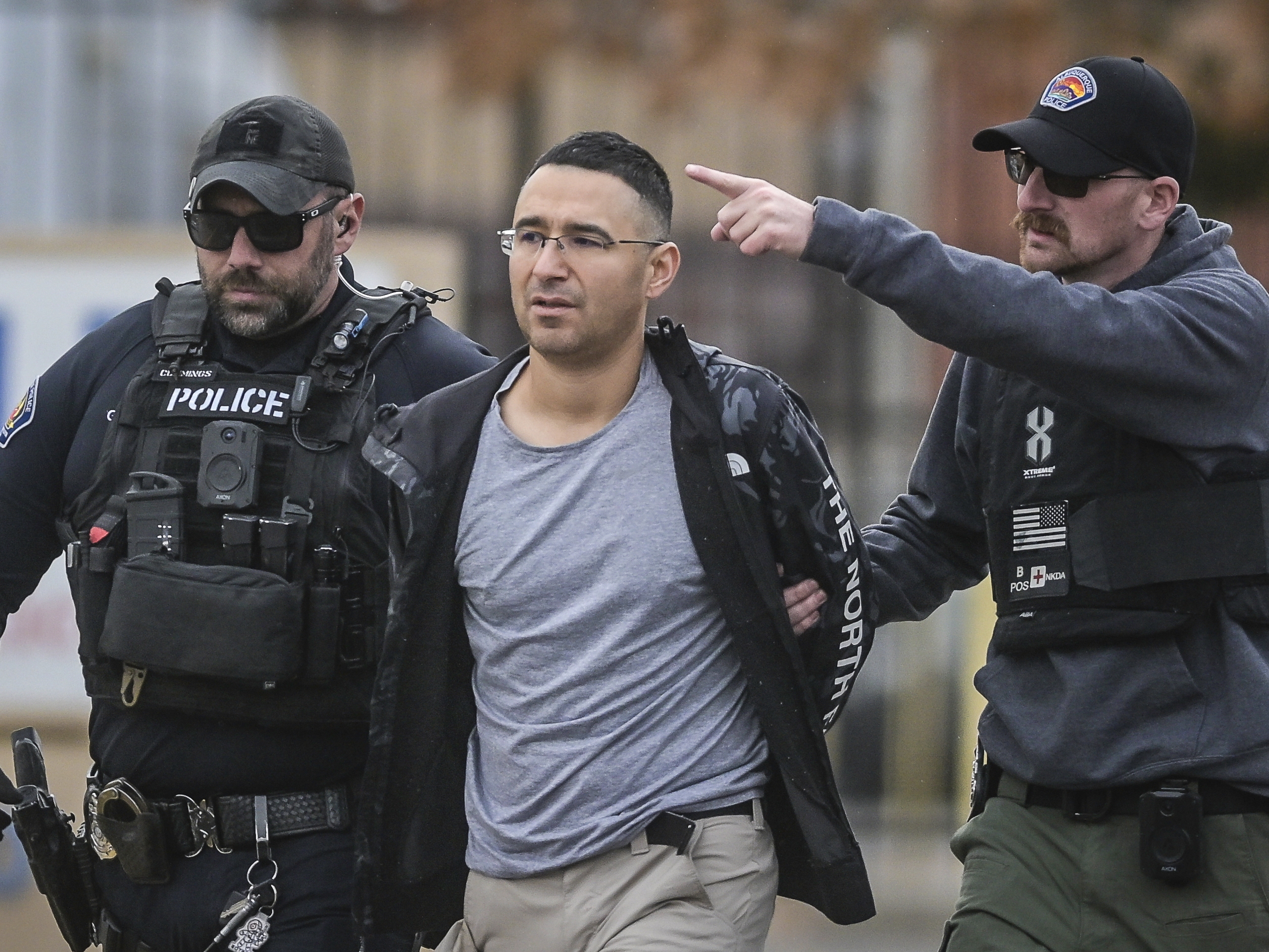 caption: FILE - Solomon Pena, center, a Republican candidate for New Mexico House District 14, is taken into custody by Albuquerque Police officers, Jan. 16, 2023, in southwest Albuquerque, N.M.