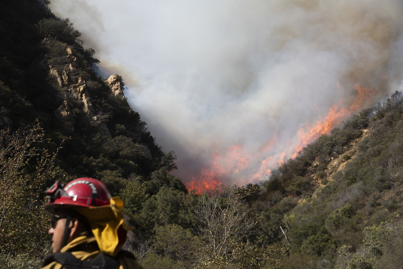 caption: A firefighter monitors a wildfires burning along a hillside Sunday, Nov. 11, 2018, in Malibu, Calif. Fire officials say the lull allowed firefighters to gain 10 percent control of the so-called Woolsey fire, which has burned more than 130 square miles in western Los Angeles County and southeastern Ventura County since Thursday. (Jae C. Hong/AP)