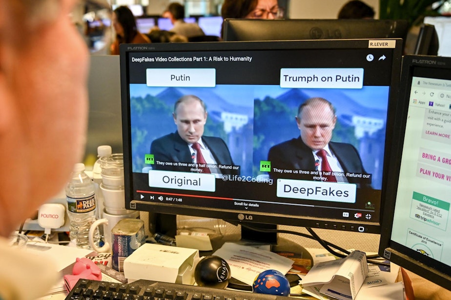 caption: A journalist views a video on Jan. 25, 2019, manipulated with artificial intelligence to potentially deceive viewers. (Alexandra Robinson/AFP/Getty Images)