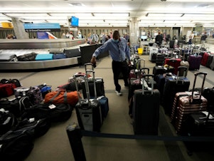 caption: Unclaimed baggage wells up between carousels for passengers arriving on Southwest Airlines flights at Denver International Airport late Sunday, Oct. 10, in Denver.