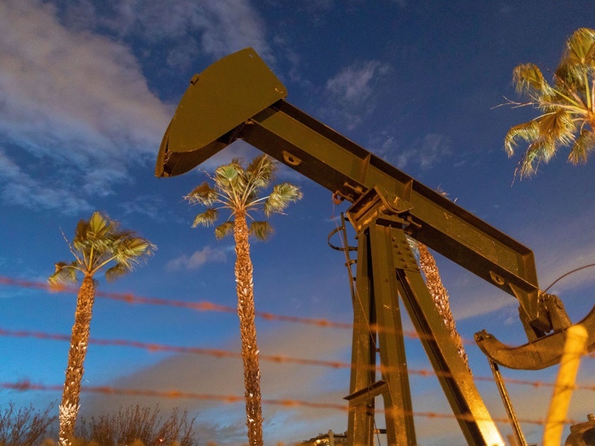 caption: Pump jacks draw crude oil near Long Beach, Calif., on March 9. A U.S. crude oil benchmark has hit 34-year lows.