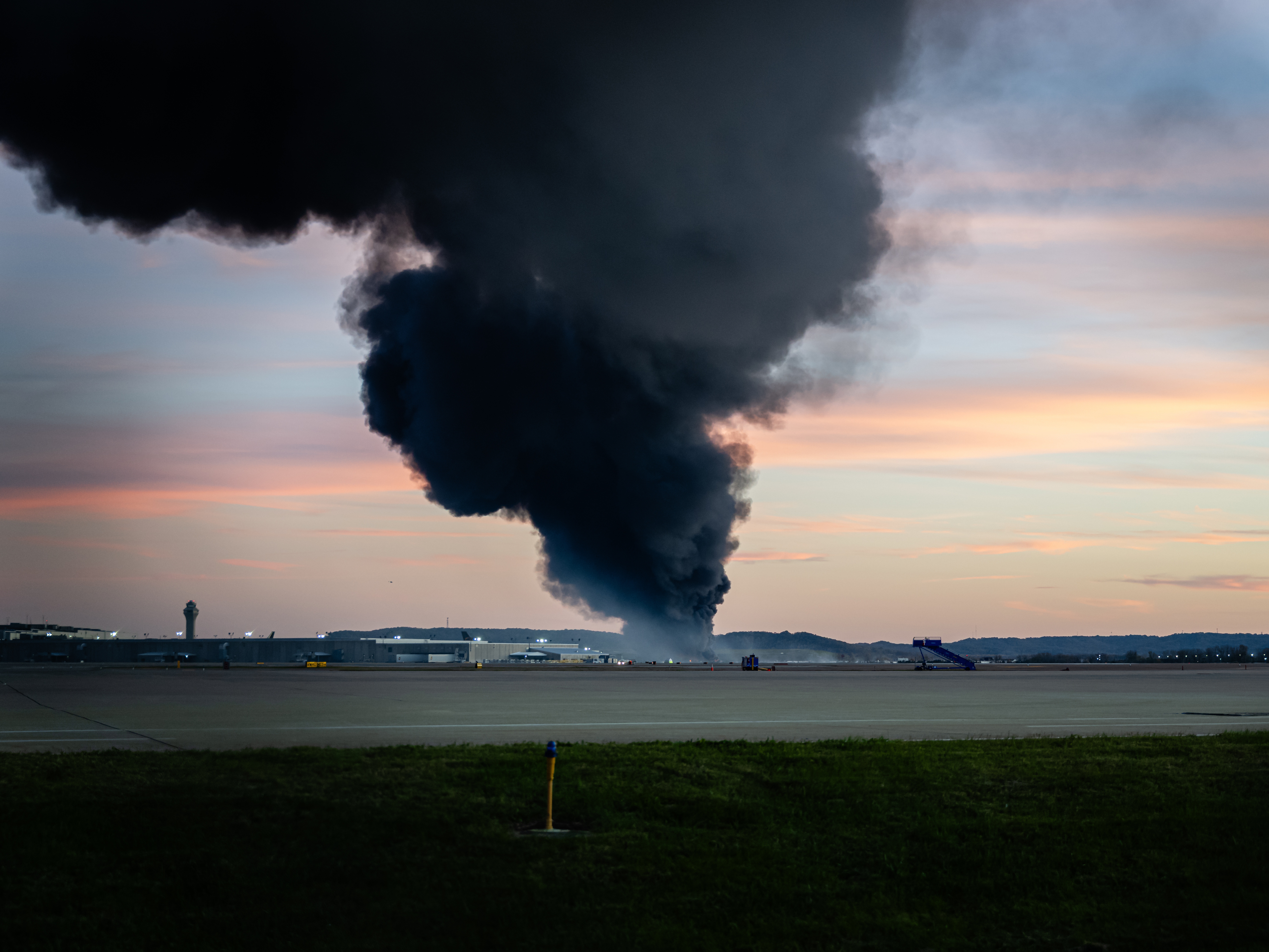 caption: A plume of smoke rises from the site of a UPS cargo plane crash at Louisville Muhammad Ali International Airport on Tuesday, Nov. 4, 2025, in Louisville, Ky.