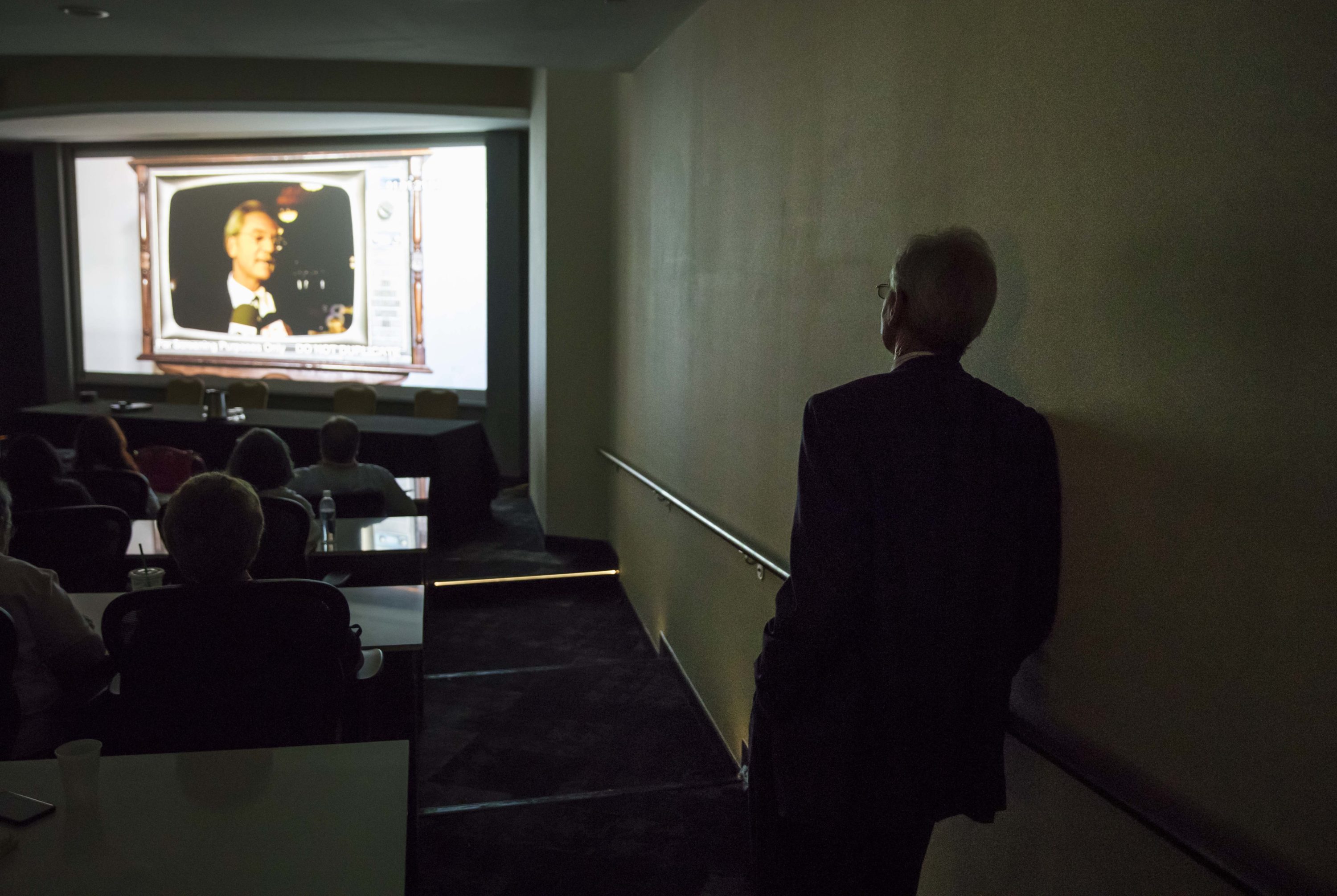 caption: Former Alabama Gov. Don Siegelman watches a screening of the documentary "Atticus v. The Architect" about his prosecution and imprisonment during the Netroots Nation conference in Atlanta, Thursday, Aug. 10, 2017. (David Goldman/AP Photo)