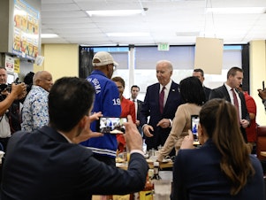 caption: President Biden greets people at CJ's Cafe in Los Angeles, Calif., on Feb. 21, 2024.